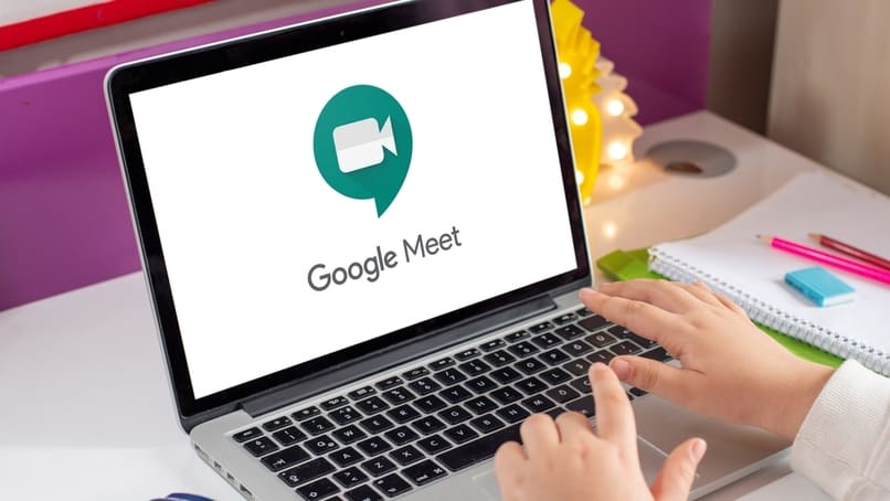 persona usando su ordenador con google meet