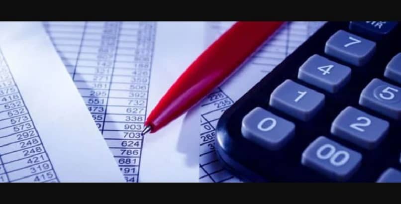 calculadora boligrafo y hojas con datos 