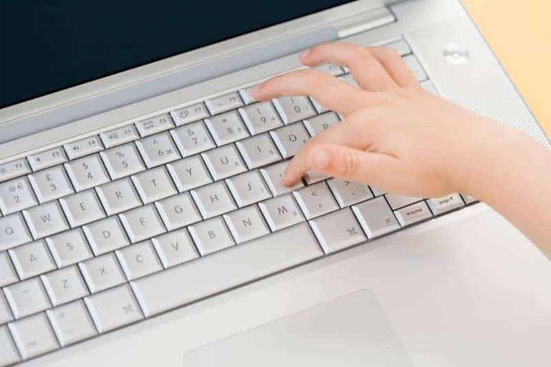 persona que utiliza un teclado de ordenador portátil