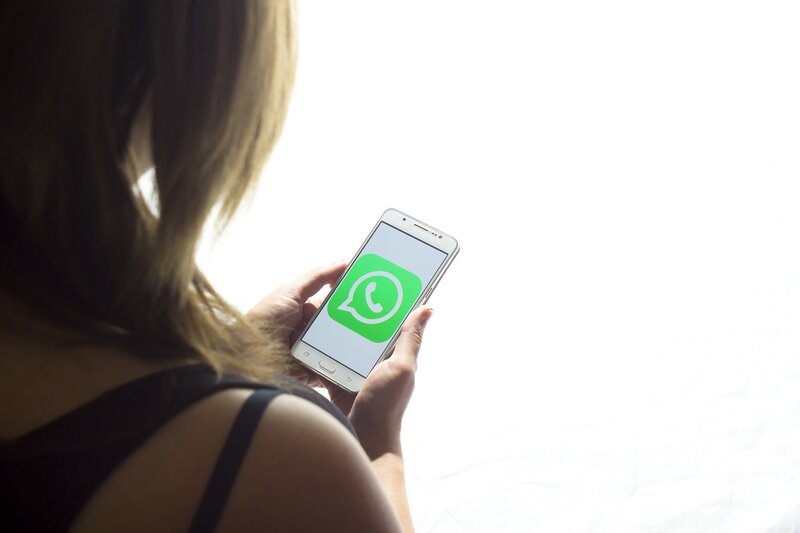mujer iniciando la aplicacion de whatsapp para ver contactos recientes