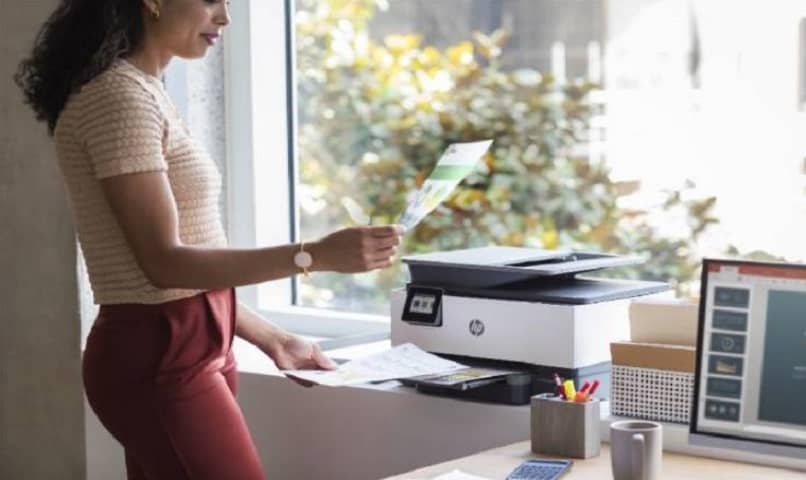 mujer utilizando impresora en oficina