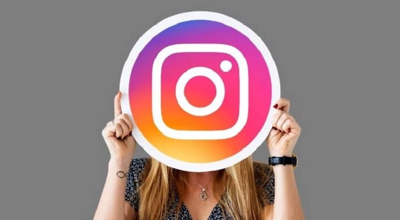 mujer sosteniendo logo de instagram