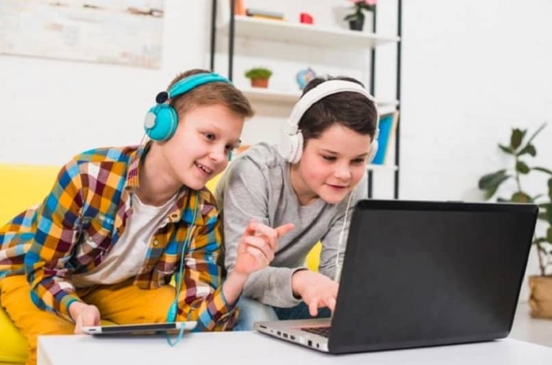 dos niños jugando en una laptop