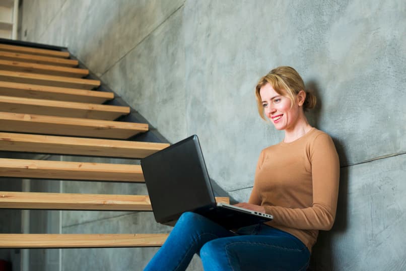 mujer sentada escaleras usando laptop 