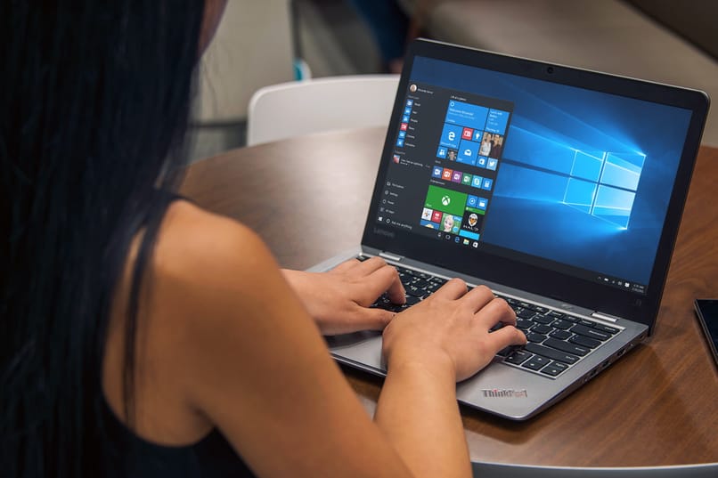 mujer usando laptop con windows